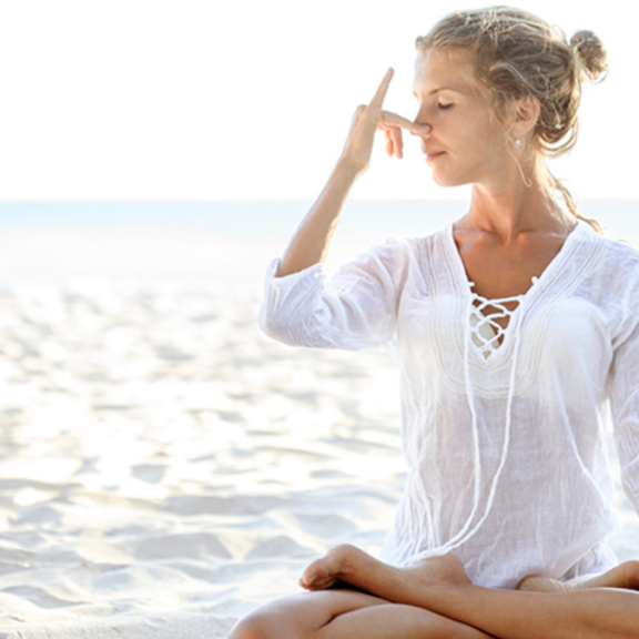 woman on beach practicing nostril breathing
