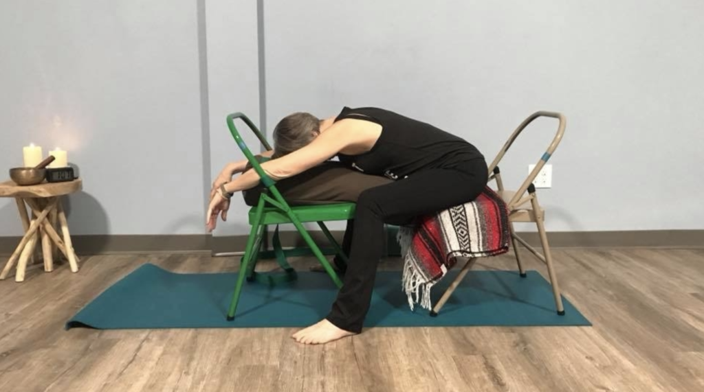 Moya McGinn Mathews demonstrates supported child's pose with two chairs and a bolster.