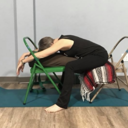 Moya McGinn Mathews demonstrates supported child's pose with two chairs and a bolster.