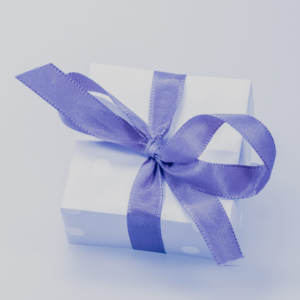 Small box wrapped in white gift paper and tied with a purple ribbon.