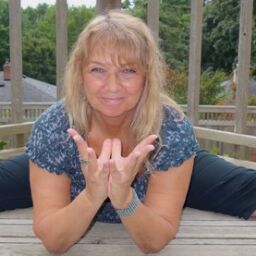 Tara Cindy Sherman demonstrates dragonfly pose and lotus mudra.